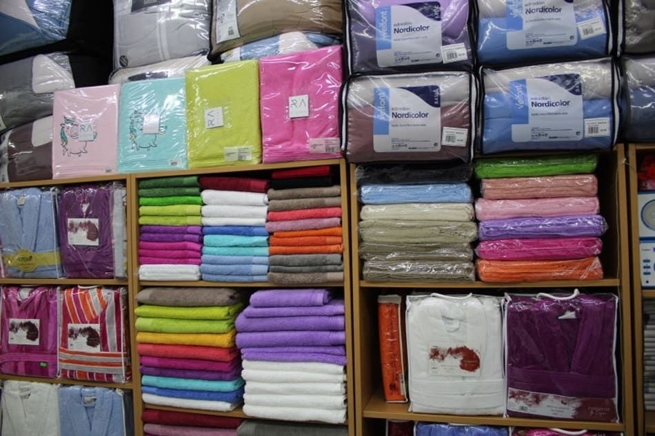 Sección de sábanas y toallas en tienda de colchones